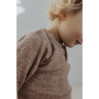 Detail houten knoopjes en ribstof Henley top Zand