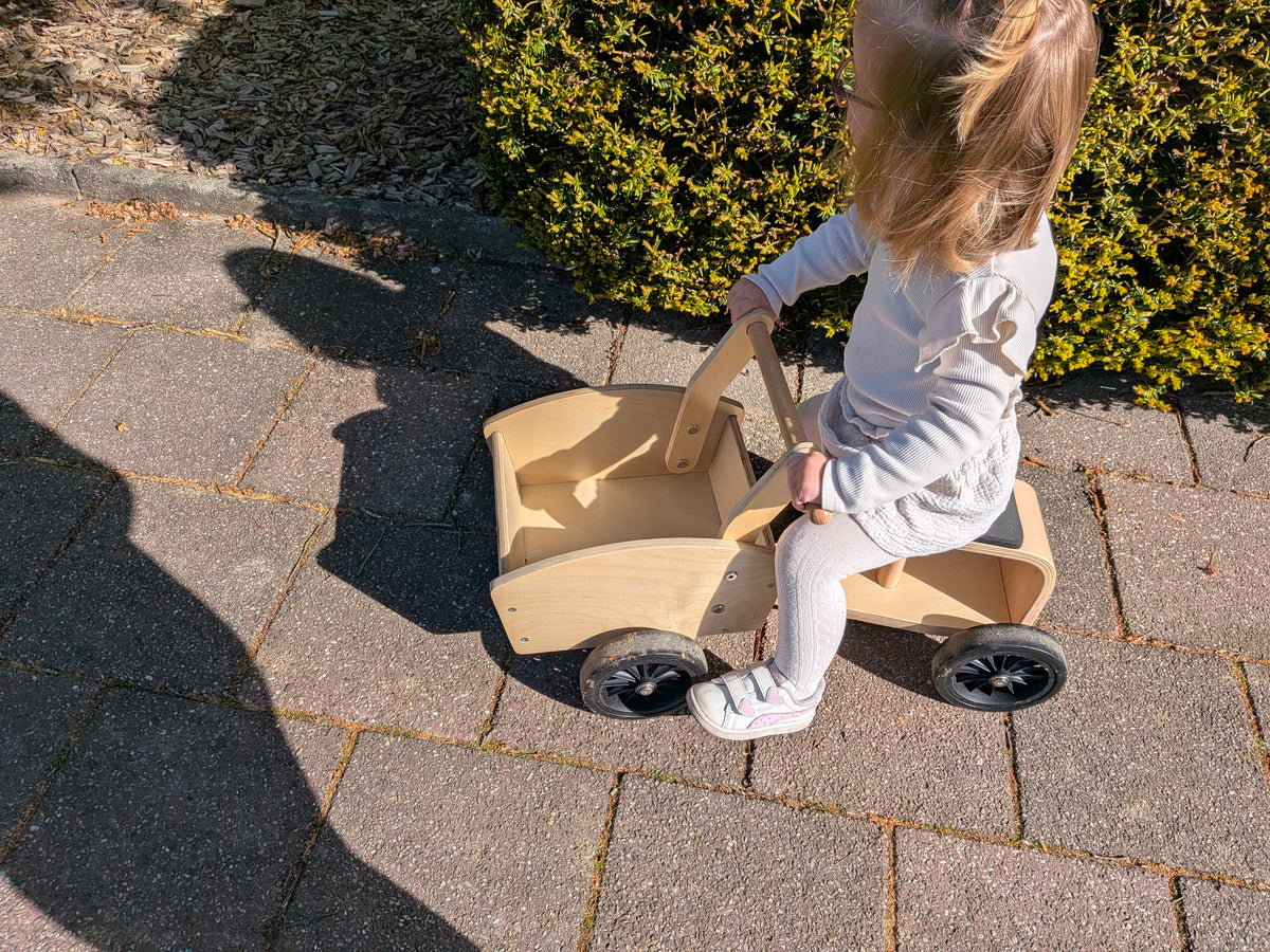 Peuter op Kinderfeets houten bakfiets in huiskamer